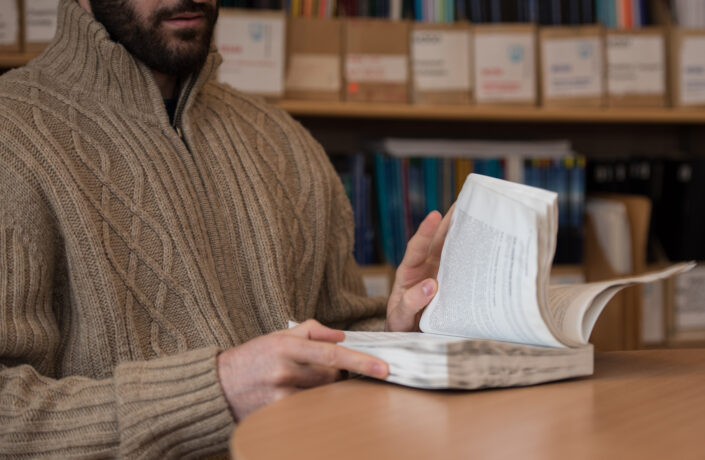 Learner in prison library with book