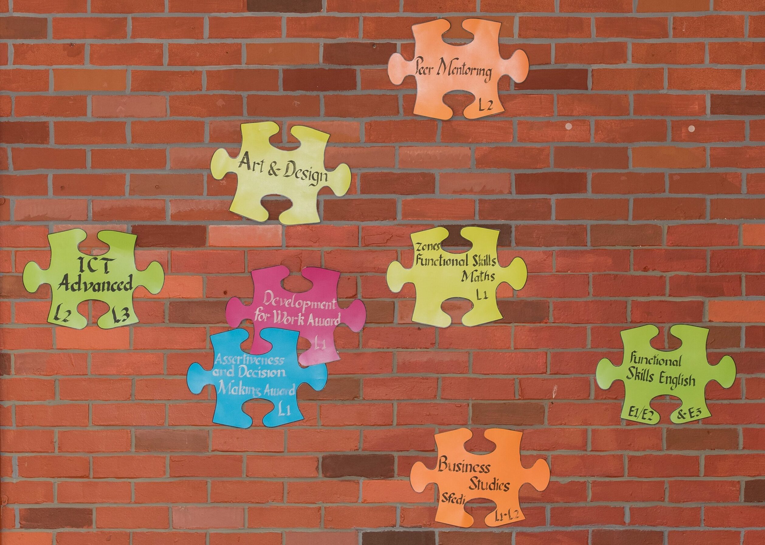 Wall decoration in prison showing different course options written on big puzzle pieces